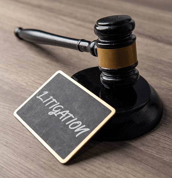 Wooden gavel beside litigation sign